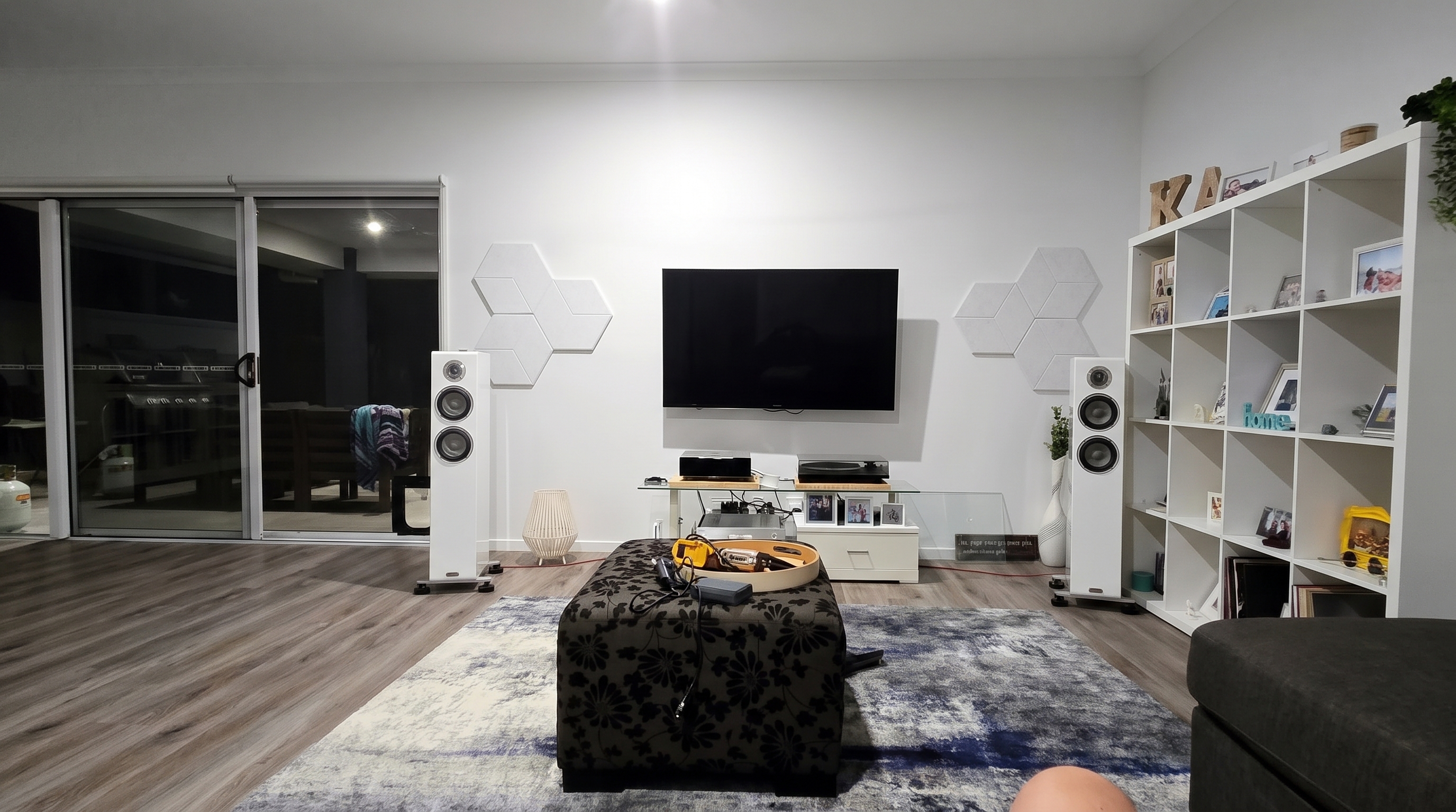 Open-plan stereo room before AudioBro V2 placement refinement, with the right speaker close to shelving.
